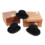 A bowler hat; together with two trilby hats in two hat boxes.