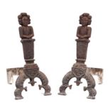 A pair of figural cast iron fire dogs, basket, accompanying set of wrought iron fire irons and a