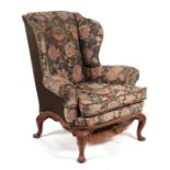 A George III style wingback upholstered armchair on cabriole front legs.Condition ReportThe