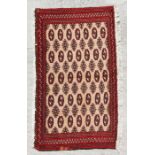 A small Persian Turkoman rug with repeat stylised design on a red ground, 126 by 64cms.