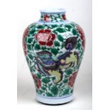 A Chinese famille verte baluster vase decorated with shishi and prunus, 19cms high