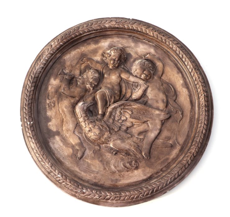 A cast plaster wall plaque decorated with cherubs in relief, 54cms diameter.