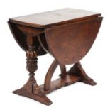 A 17th century style oak drop-leaf occasional table with carved urn supports, 68cms wide.