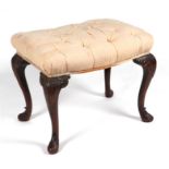 A George III style mahogany upholstered footstool with acanthus leaf carved cabriole legs, 54cms