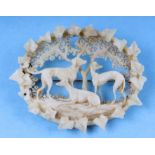 A late 19th century carved stag antler brooch depicting three lurchers stood beneath a tree. 6.5cm