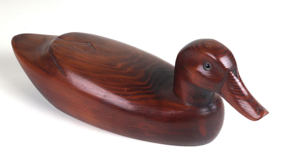 A well carved wooden decoy duck with inset glass eyes, approx 32cms long.