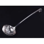 A large 18th century unmarked silver ladle with eagle's head handled terminal and scallop shell bowl