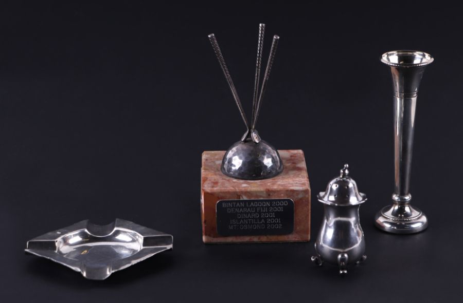 A small collection of silver items to include an ashtray, a pepper, a trumpet form posy vase, and