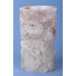 A Chinese carved stone brush pot decorated with figures in a landscape, 13cms high.