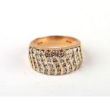 A 14ct gold ring set with fifty five diamonds in a wave pattern, approx UK size 'O', 10.1g.