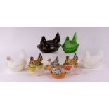 A group of ceramic and glass hens on nests to include two milk glass examples, largest 14cms wide (