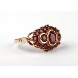 A 9ct gold garnet cluster ring with three central larger stones, approx UK size 'R', 5.8g.