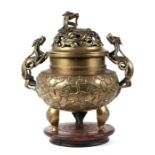 A large Chinese bronze two-handled censer on a hardwood stand, the pierced top with dragon finial,