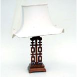 A Chinese hardwood table lamp, 56cms high including shade.