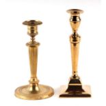 A brass candlestick in the Adam taste, 21cms high; together with another similar, 19cms high (2).