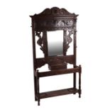 A Victorian oak hall stand with profusely carved decoration, bevelled glass mirror, glove box and