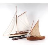 A scratch built model of a single sailed boat, 46cms long; together with a model of a sailing yacht,
