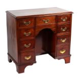 A 19th century mahogany kneehole desk with an arrangement of nine drawers, the well with a