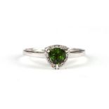 A 9ct white gold ring set with a triangular green stone (possibly tourmaline) surrounded by