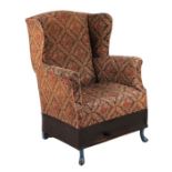 A George III style wingback armchair on slipper front feet.