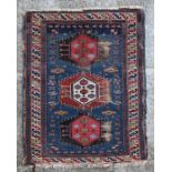 A Persian Qashqai rug with geometric motifs on a blue ground within a multi geometric border, 140 by