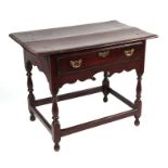 A George III oak side table, the rectangular top above a single frieze drawer and shaped apron, on