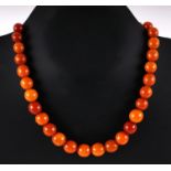 A butterscotch amber graduated round bead necklace, 44cms long, the largest bead 12mm, total