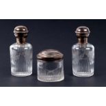 A pair of continental cut and etched glass dressing table bottle with white metal top engraved a