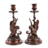 A pair of 19th century bronze candlesticks with eagle and snake columns, 23cms high (2).