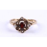 A 9ct gold dress ring set with an oval red stone flanked by two white stones, approx UK size 'L,