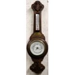 An Edwardian barometer thermometer in a carved oak case, 67cms high.