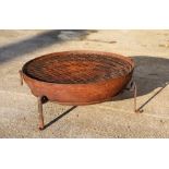 A large iron fire pit on tripod stand, 90cms diameter.