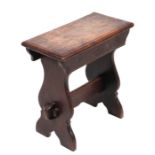 An oak stool with rectangular top above shaped supports joined by a stretcher, 48cms wide.