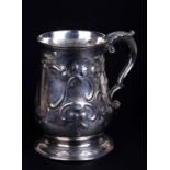 A Victorian silver pint tankard with glass base, embossed foliate decoration and initialled