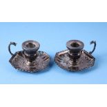 A pair of Persian silver miniature chambersticks in the European taste with chased and repousse
