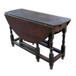An 18th century oak gateleg table on turned supports with a short drawer at either end, 130cms