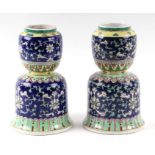 A pair of Chinese famille vert vases decorated with foliate scrolls on a blue ground, 24cms high (