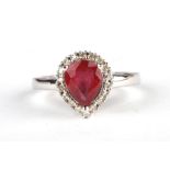 A 9ct white gold ring set with a pear shaped red stone surrounded by diamonds, approx UK size 'N',