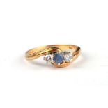 An 18ct gold diamond and sapphire three-stone ring, the central pale sapphire flanked by two