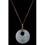 A Chinese yellow metal mounted pale jade pierced disc pendant on a fine 18ct gold chain. Chain