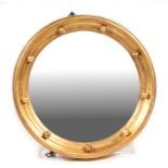 A gilt framed circular convex mirror with ball decoration, overall 45cms diameter.