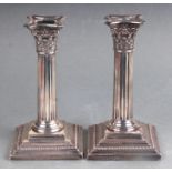 A pair of Victorian dwarf silver Corinthian column candlesticks on square stepped bases, London