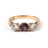A 9ct gold ring set with a central amethyst flanked by two white stones, approx UK size 'K', 2.2g.