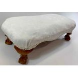 A 20th century footstool, raised on ball and claw