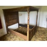 A 20th century oak style four poster bed, carved with in