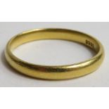 A yellow metal court wedding band stamped 22ct 2.5