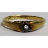 A yellow metal ring set with a single diamond, sta