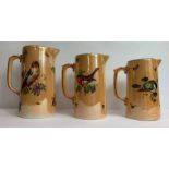 A set of three Edwardian lustre graduated jugs, de