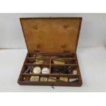 A wooden case containing vintage watch parts to in