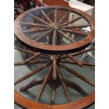 A revolving circular glass top pedestal table with